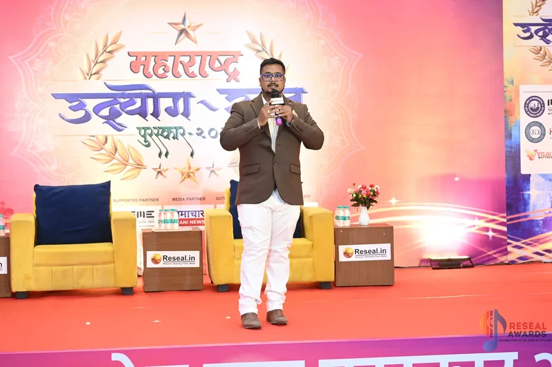 Nikhil Gadkarr addressing the room from the stage at the Maharashtra Udyog Ratna ceremony